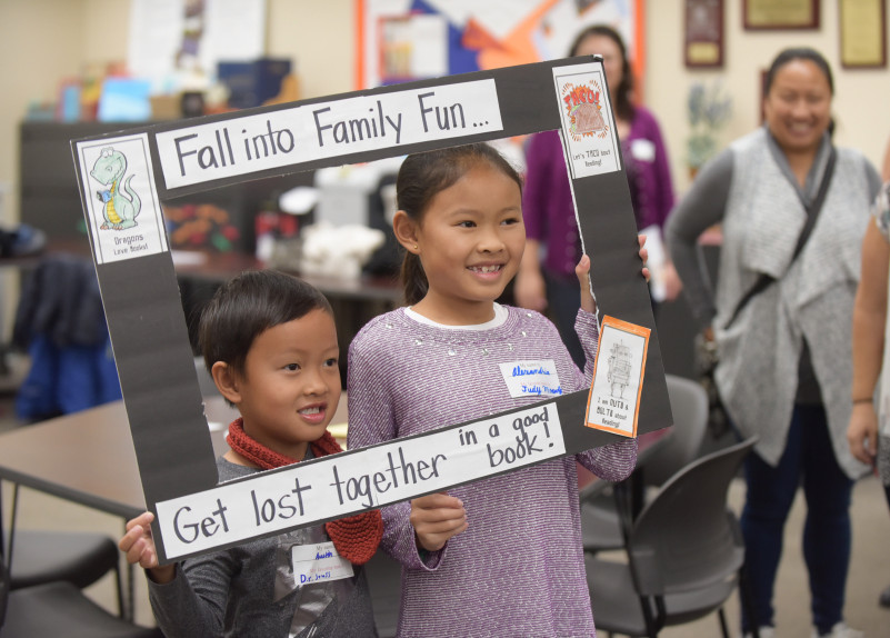two children inside of a fall reading day photo frame
