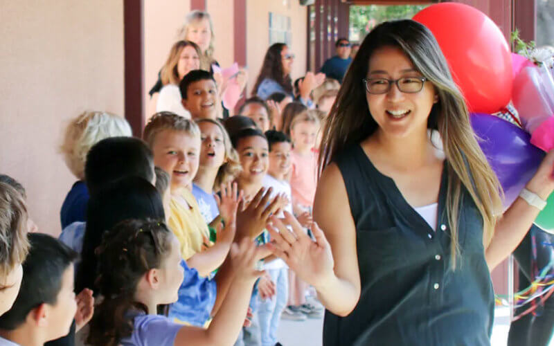 Vivian Chang high-fives students