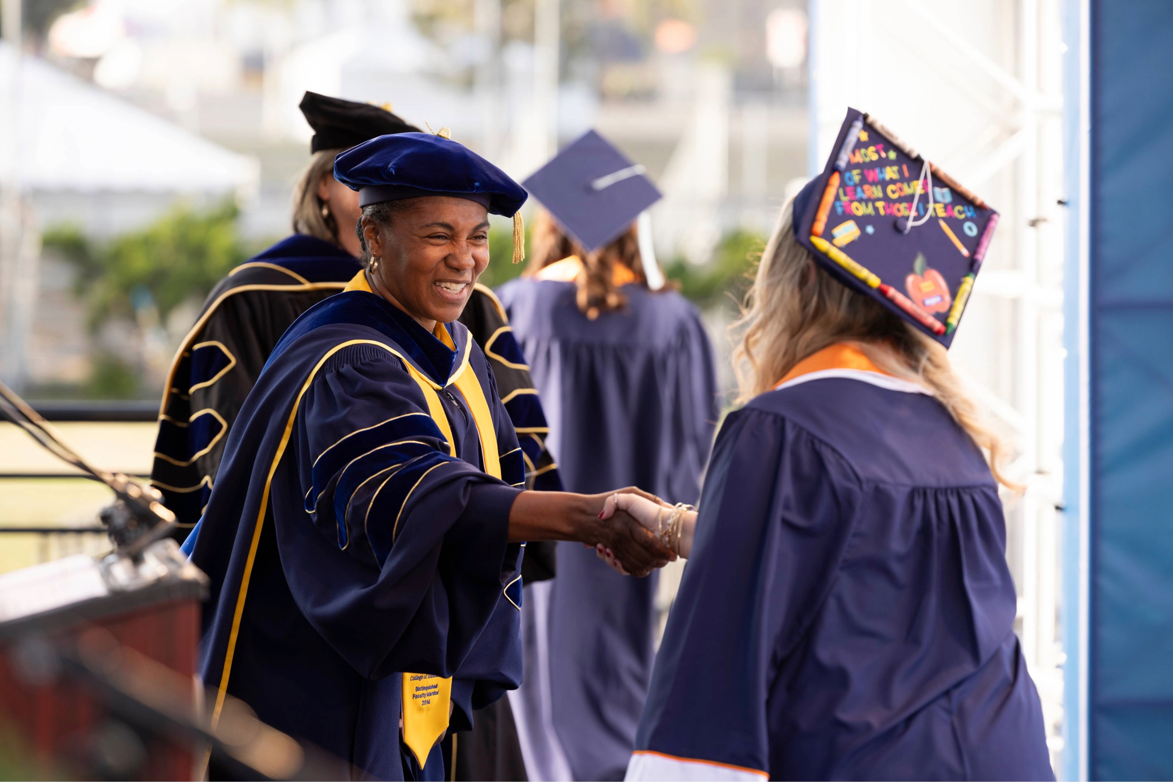 graduate shaking hands on stage receiving their diploma