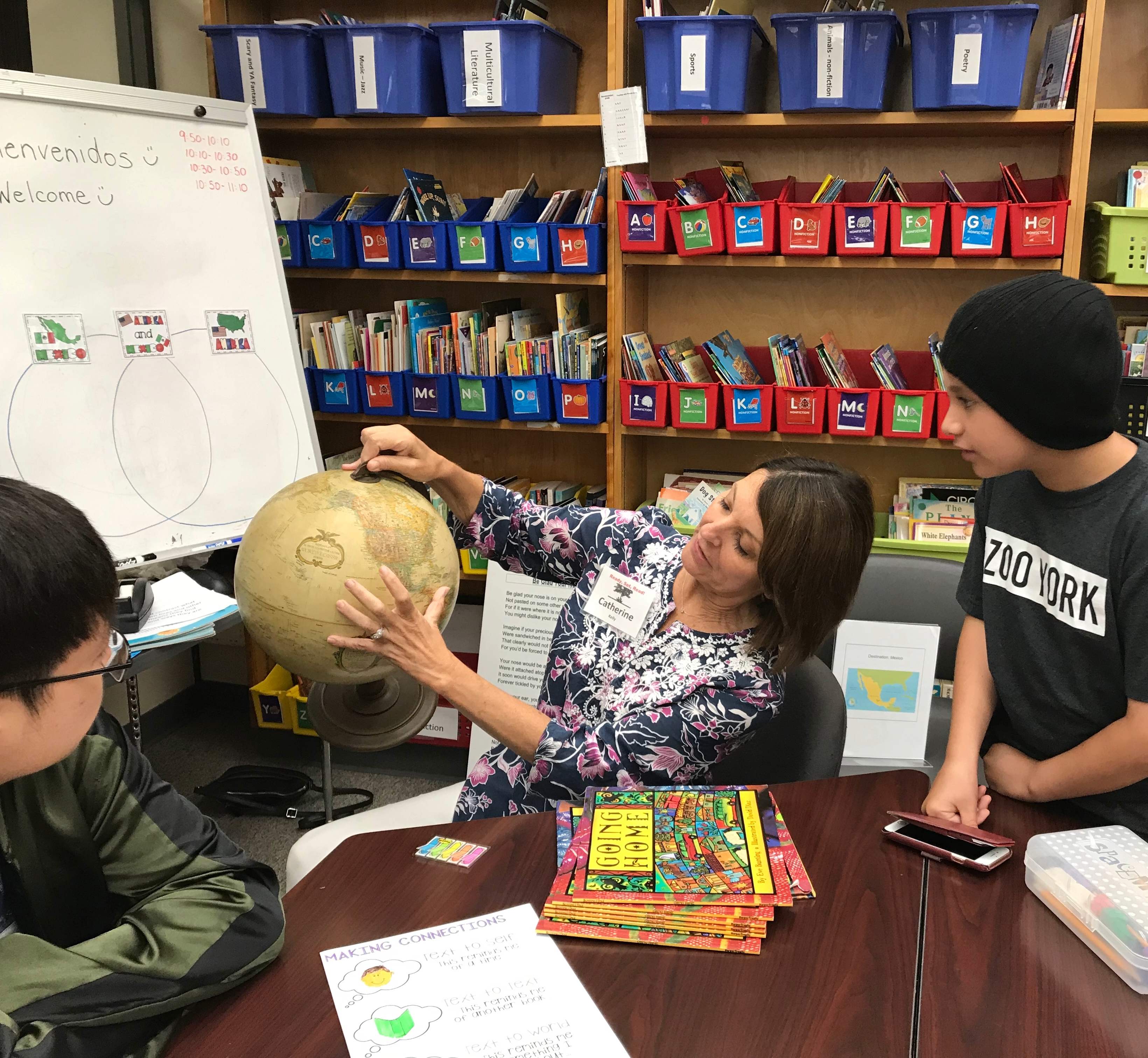 Students watching teacher explain with a globe